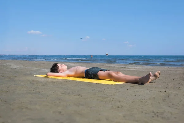 Teen Boy Leżącego Żółtym Ręczniku Sunbathes Plaży — Zdjęcie stockowe