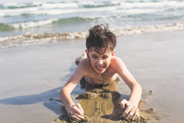 Ragazzo Strizzato Sulla Sabbia Sulla Spiaggia Sullo Sfondo Del Mare — Foto Stock