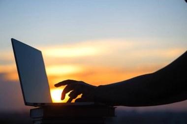 Kadın öğrenci gün batımı kasaba arka planda üniversite sınavı geç akşam hazırlanıyor sonra onu laptop kapanış. Eğitim konsepti