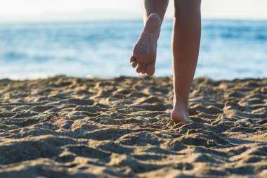 Sahilde kadın bacakları.