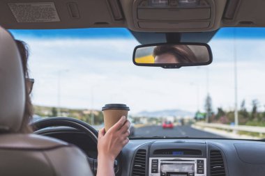Kız İtalya'da otobanda araba kullanıyor. Arabanın arka koltuğundan ön cam, yol ve sürücü görünümü