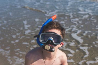 Denizde rahatlatıcı maskeli genç çocuk