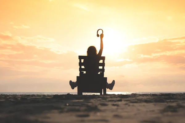 Chica Con Auriculares Está Sentado Tumbona Escuchando Música Playa Atardecer —  Fotos de Stock