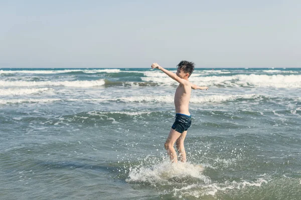 Ragazzo Sulla Spiaggia Onde Marine Con Spruzzi Acqua Concetto Vacanza — Foto Stock