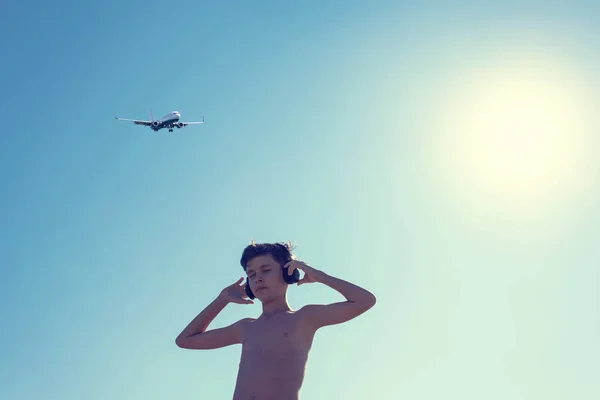 Silhueta Menino Adolescente Praia Nos Fones Ouvido Frente Sol Avião — Fotografia de Stock