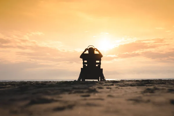 Dziewczyna Słuchawkach Siedzi Leżaku Słuchania Muzyki Plaży Zachodzie Słońca Koncepcja — Zdjęcie stockowe