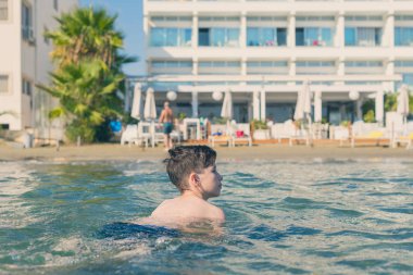 13 yaşında çocuk yüzme ve gevşeme deniz dalgaları. Aile yaz tatili kavramı 