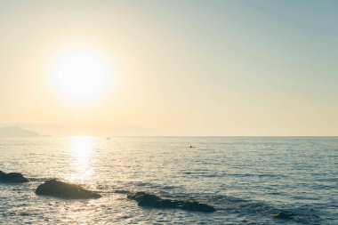 Günbatımı arka planında deniz ve kıyı manzarası 