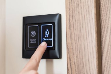 Otel odasının elektronik ekranındaki temizleme butonuna kadın parmağı basıyor. Akıllı otel odası. oda servisi 