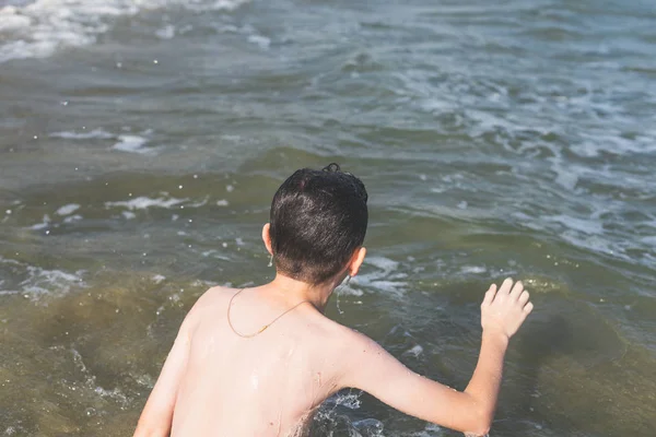 熱帯のリゾート地で海の波の中で泳ぐ十代の少年 夏休みの概念 — ストック写真