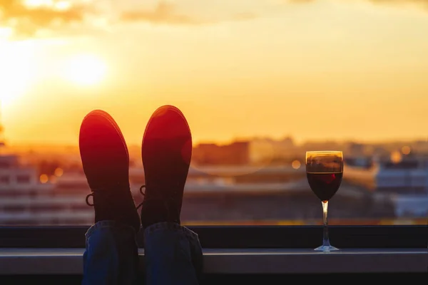 Silhuett Man Fötter Med Glas Rött Vin Balkongen Stadens Bakgrund — Stockfoto