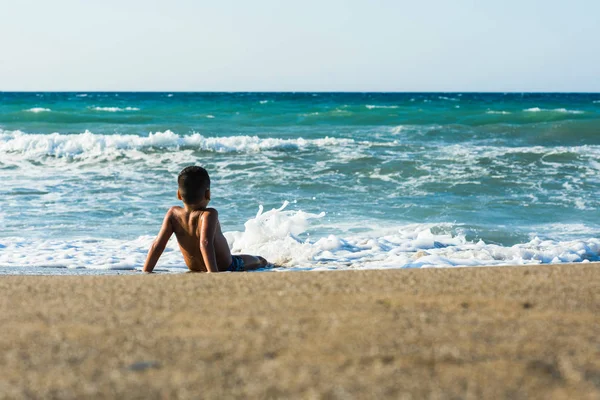 13 years old boy swimming and relaxation in the sea waves. Concept of family summer vacation