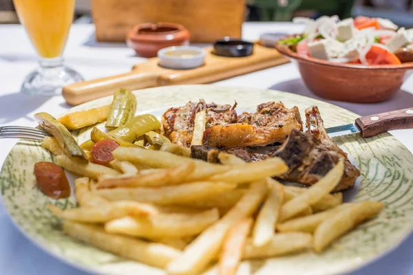 在希腊餐厅或小酒馆的盘子里 羊排配蔬菜和烤土豆 — 图库照片