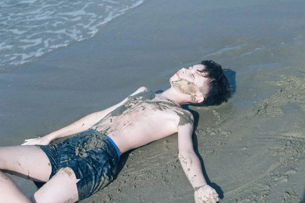 Feliz Adolescente Menino Divertindo Deitado Areia Praia — Fotografia de Stock