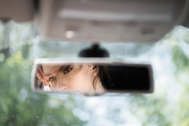 Arabanın dikiz aynasında güzel bir genç kadın yüz yansıması. Kavram