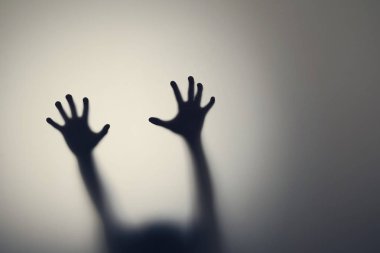 Cam kapının arkasında kadın ellerinin koyu silueti. Depresyon, korku, panik atak kavramı