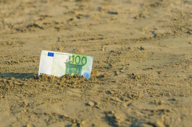 Sahilde kum yüz euro değerinde Banknot. Ucuz seyahat ve tatil kavramı. Promosyon ve indirim