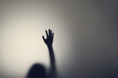 Cam kapının arkasında kadın ellerinin koyu silueti. Depresyon, korku, panik atak kavramı