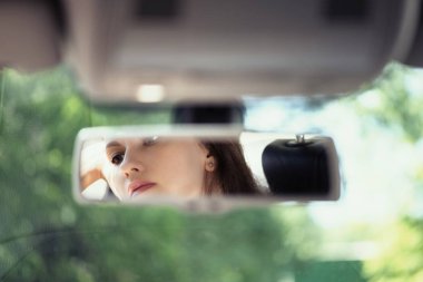 Arabanın dikiz aynasında güzel bir genç kadın yüz yansıması. Kavram