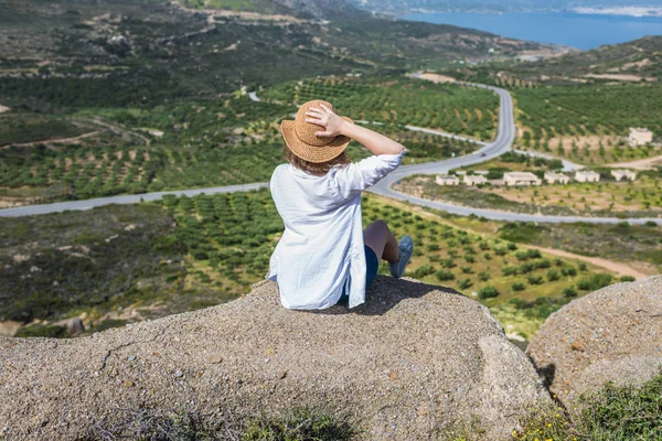 Woman in tourist clothes  on top of a mountain.