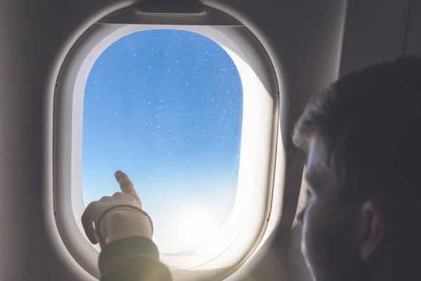 少年は飛行機の窓や玄関を見る飛行をしている — ストック写真