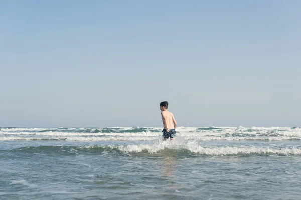 Αγόρι Στην Παραλία Στα Κύματα Της Θάλασσας Πιτσιλίσματα Νερού Έννοια — Φωτογραφία Αρχείου