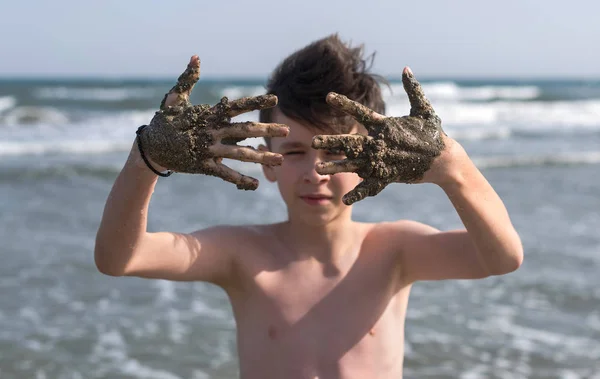 Alegre Menino Adolescente Mostra Suas Mãos Lama Cura Mar — Fotografia de Stock