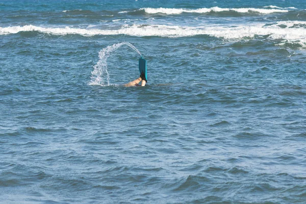 legs of diving man in the swim flippers above the storm waves