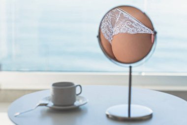 Bir masa aynasında dantel külot çıplak kadın kalça yansıması. Yaşam tarzı kavramı