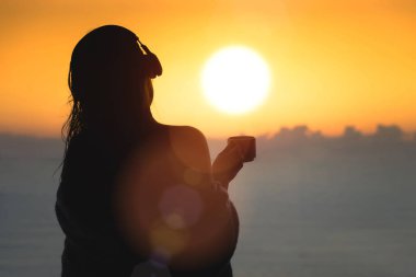 Sahilde gün batımında bir kadın