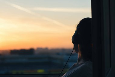 Günbatımında şehir içinde müzik dinlemek kulaklık kız 
