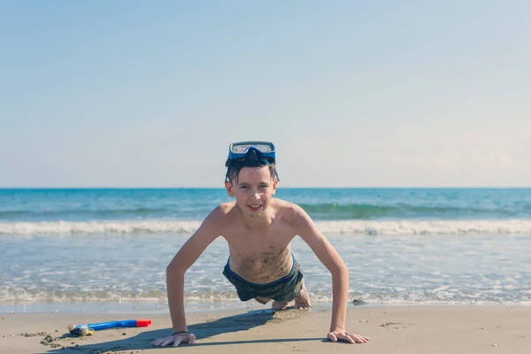 男孩在浮潜面具和管在海滩上的海上背景 体育理念与健康生活方式 — 图库照片