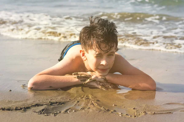 Felice Adolescente Ragazzo Diverte Sdraiato Sulla Sabbia Spiaggia Tramonto — Foto Stock