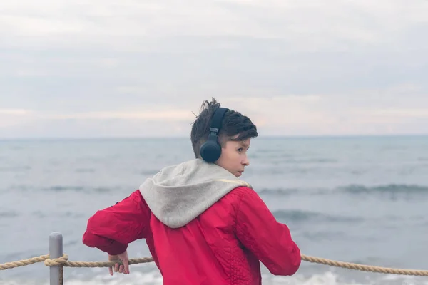 Boy Red Jacket Headphones Looks Sea Waves Stormy Rainy Weather — Stock Photo, Image