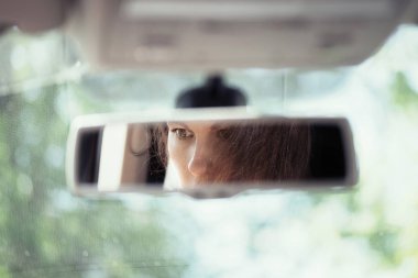 Arabanın dikiz aynasında güzel bir genç kadın yüz yansıması. Kavram