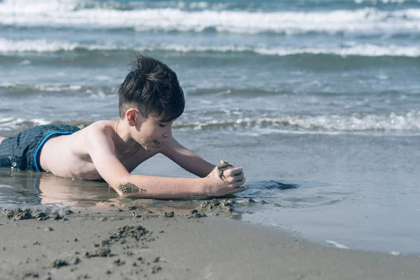 Gelukkige Tiener Jongen Met Plezier Liggend Het Zand Het Strand — Stockfoto