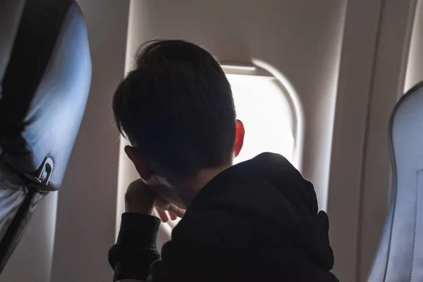Een Jongen Heeft Een Vlucht Kijkend Door Het Vliegtuigraam Patrijspoort — Stockfoto
