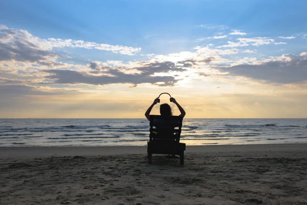 Chica Con Auriculares Está Sentado Tumbona Escuchando Música Playa Atardecer —  Fotos de Stock