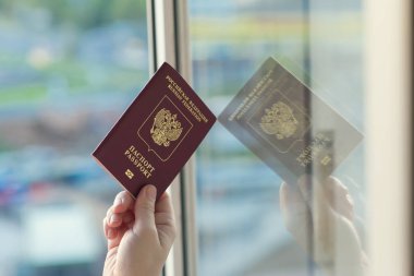 Pencerede beyaz pasaport tutan kişi 