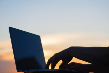 Kadın öğrenci gün batımı kasaba arka planda üniversite sınavı geç akşam hazırlanıyor sonra onu laptop kapanış. Eğitim konsepti