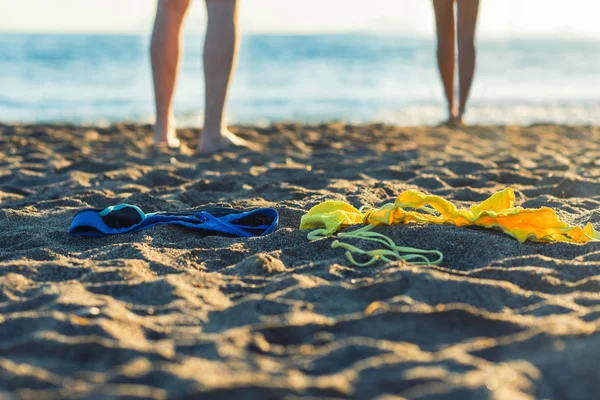 Female Male Legs Bikini Swimming Trunks Sand Sunset Background Concept — Stock Photo, Image