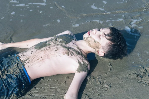 Gelukkige Tiener Jongen Met Plezier Liggend Het Zand Het Strand — Stockfoto