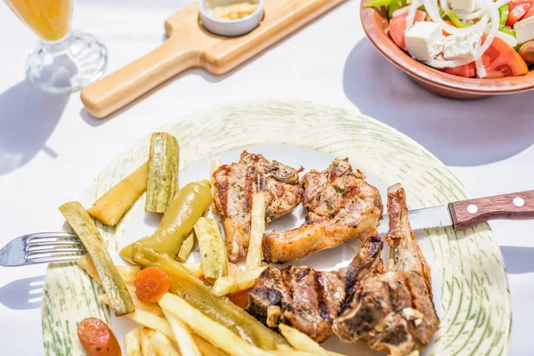在希腊餐厅或小酒馆的盘子里 羊排配蔬菜和烤土豆 — 图库照片