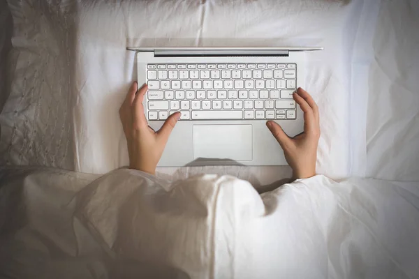 담요로 침대에 노트북과 여자는 일해야 합니다 — 스톡 사진