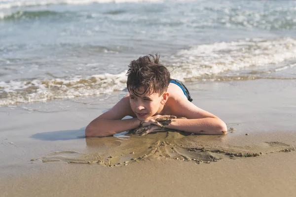 Ragazzo Strizzato Sulla Sabbia Sulla Spiaggia Sullo Sfondo Del Mare — Foto Stock