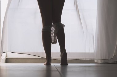 Seksi bacaklar perdelerin arka planında bir odada onu beyaz külot çıkararak güzel kadının siluet alt görünümü