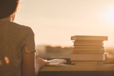 Gün batımı kasaba arka plan üzerinde üniversite sınavı için hazırlık kitapları bir sürü kız öğrenci. Eğitim kavramı