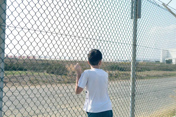 Menino Descalço Fica Praia Perto Rede Ferro Olha Para Aeroporto — Fotografia de Stock