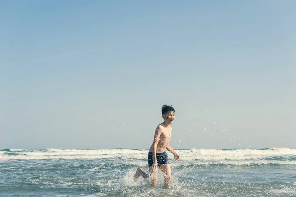 Chłopiec Plaży Fale Morskie Rozpryskami Wody Koncepcja Wakacji Letnich — Zdjęcie stockowe