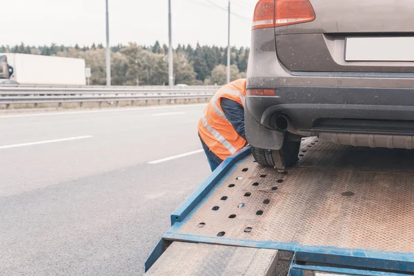 Tow truck towing a broken down car on the highway